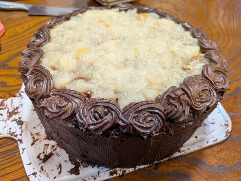 バラの花のようなチョコレートの飾りをあしらった大きな誕生日ケーキ